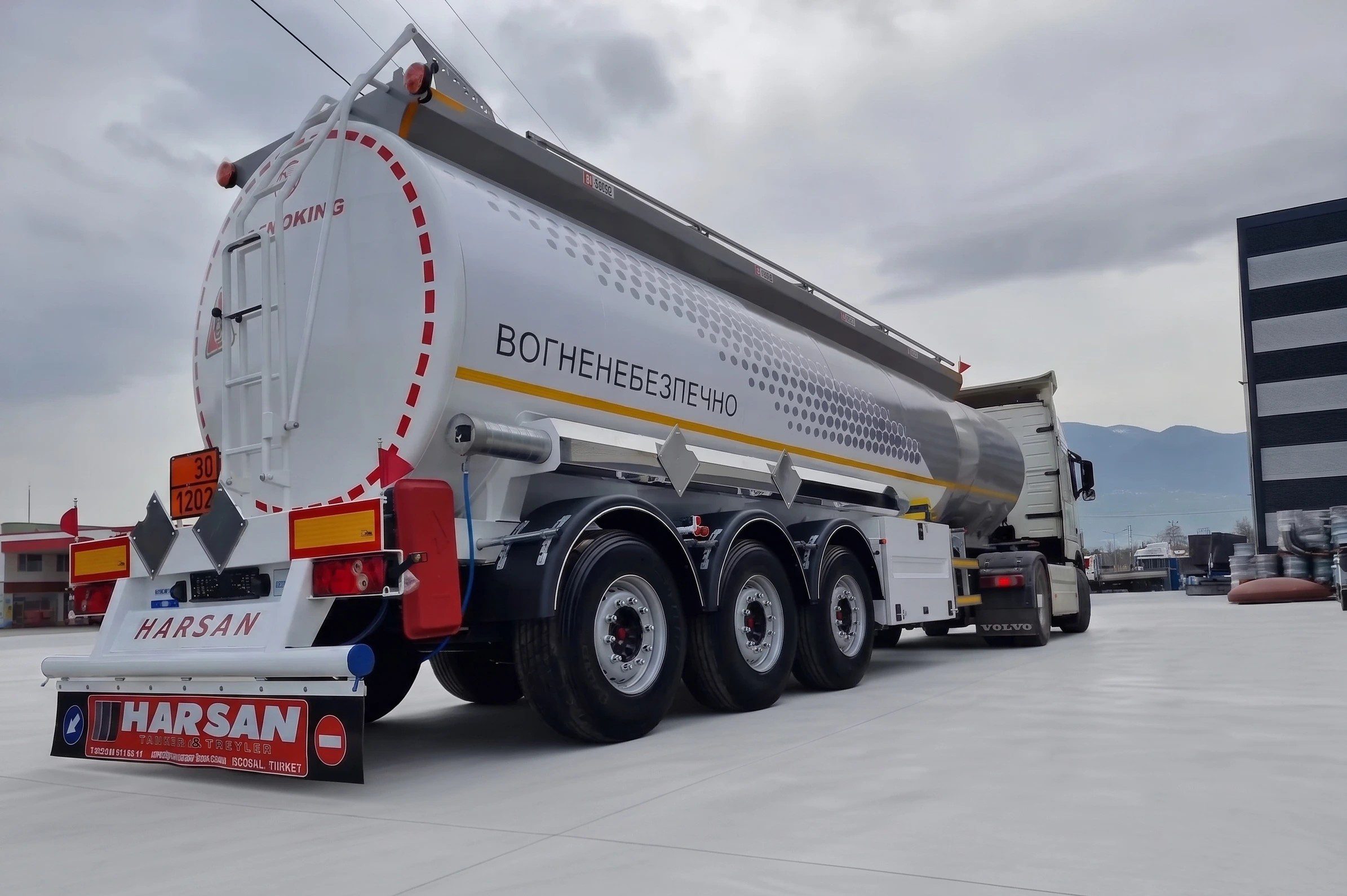 ADR tehlikeli madde güvenlik işaretlerine sahip, Harsan Tanker tesislerinde üretilmiş üç dingilli akaryakıt taşıma yarı römorku arka görünümü.