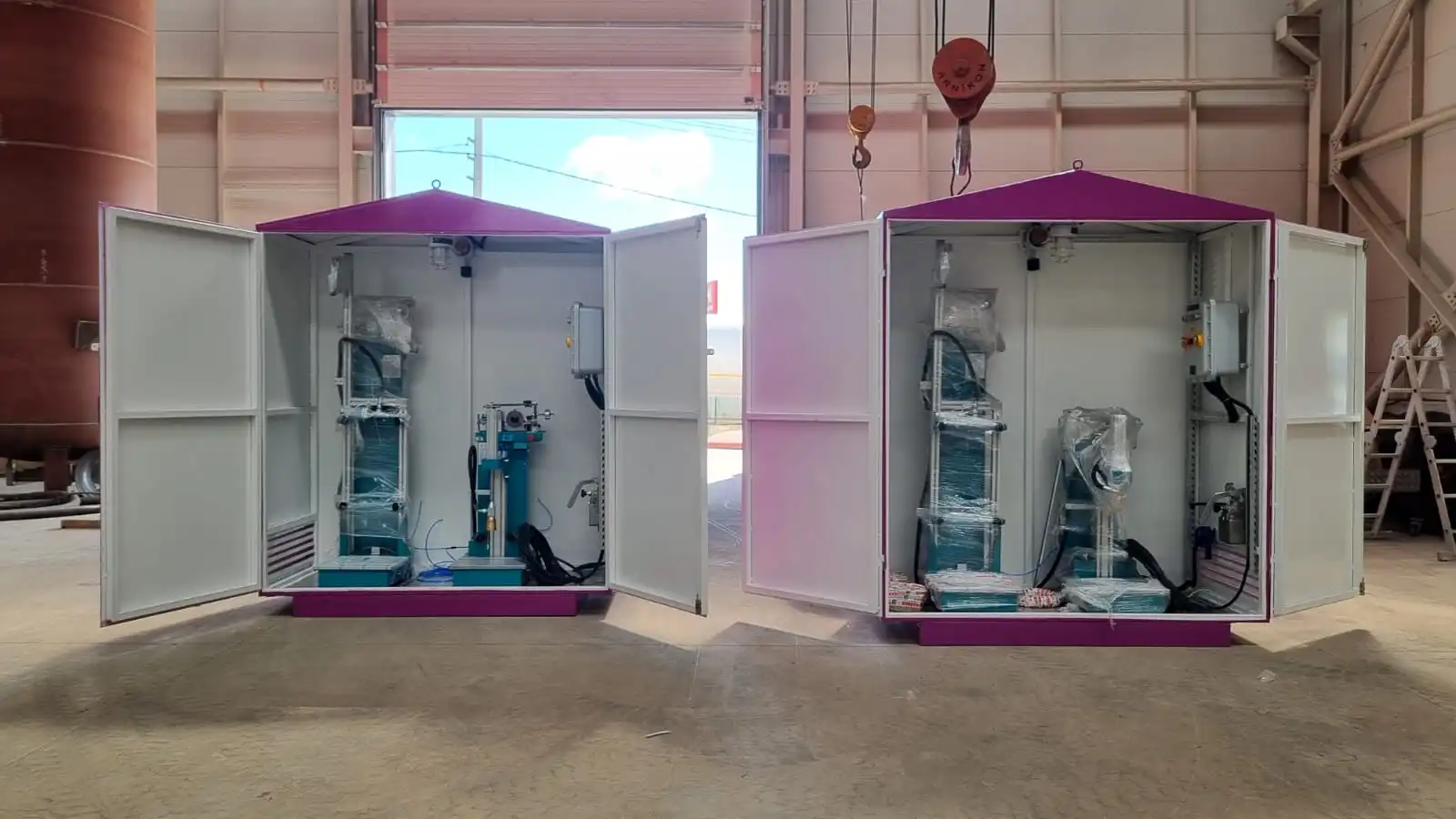 Kapakları açık halde iç tesisatı, borulaması ve çift tüp dolum terazisi görünen, magenta (mor) renkli korumalı LPG dolum kabinleri.