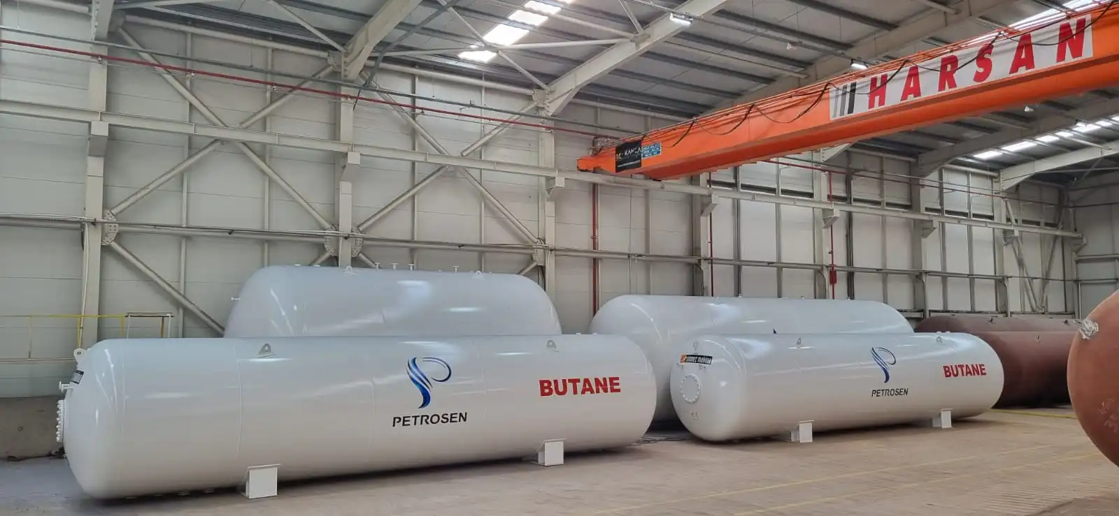 Fabrika içinde son kontrolleri yapılan, beyaz renkli yatay LPG depolama tankları.